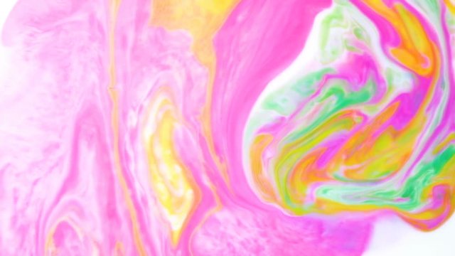 Abstract psychedelic background. Yellow ink mixed with pink and green inks in milk slow motion