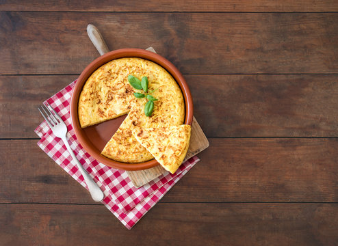 Traditional spanish omelette close up,  view from above. Spanish tortilla on a rustic wooden texture with a place for text.