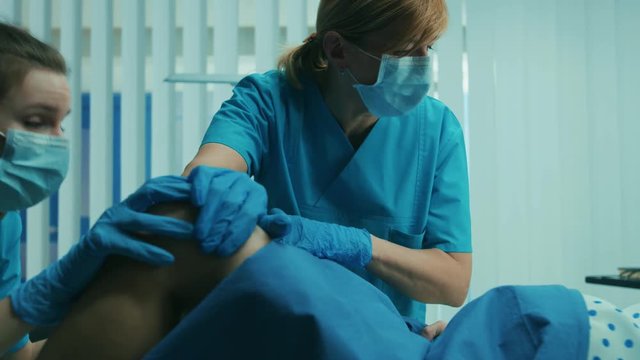 In the Hospital Close-up on Woman in Labor Pushes to Give Birth, Obstetricians Assisting. Modern Delivery Ward with Professional Midwives.  Shot on RED EPIC-W 8K Helium Cinema Camera.