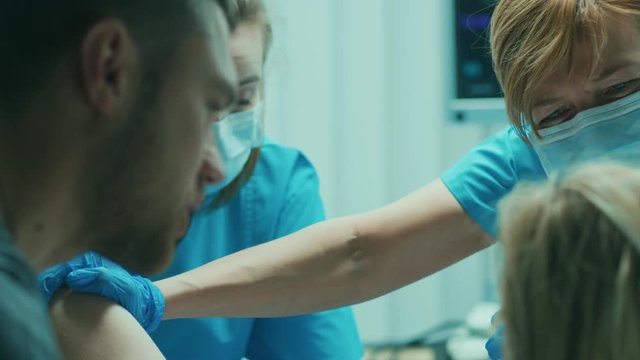 In the Hospital Woman Giving Birth, Husband Holds Her Hand in Support, Obstetricians Assisting. Modern Delivery Ward with Professional Midwives. Shot on RED EPIC-W 8K Helium Cinema Camera.