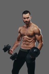 Fototapeta na wymiar A Muscular guy working out with dumbbells. Isolated on a gray ba