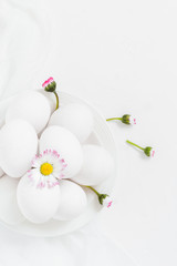 Fototapeta na wymiar Spring Easter background with white eggs Daisy flowers