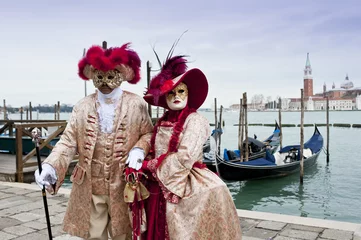 Fototapeten Couple of carnival masks in St. Mark's Square in Venice. In the background the church of San Giorgio.Italy © dianacrestan