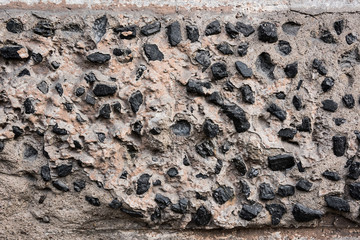 The texture of a wall covered with concrete with large stones