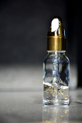 Obraz na płótnie Canvas Luxurious facial serum container with dropper on black background