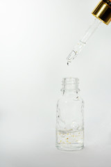 Luxurious facial serum container with dropper on white background