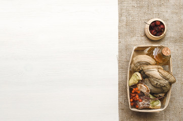 Herbal medicine. Alternative medicine concept. Wild dry rowan berry medicinal tincture and medical fungus Betulinus on white wooden background with copy space.