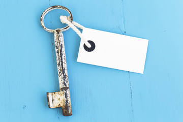antique  old key on blue rustic wood background (mavi tahta eski anahtar tek ) Old rusty key with a paper label lies on a wooden board 