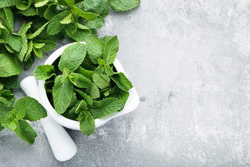 Fresh mint leafs in mortar on grey wooden table © 5second