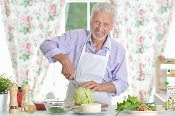 Senior man preparing dinner in kitchen