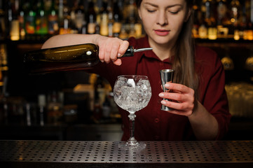 Female barman pouring bitter for making an Aperol syringe cocktail