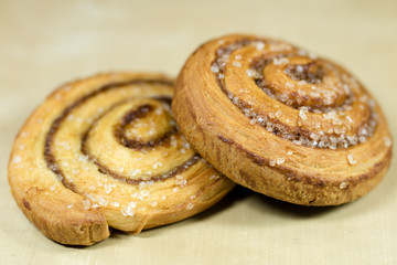 Fototapeta premium Tasty curly cinnamon cake. Sweet pastries on a dark kitchen table.