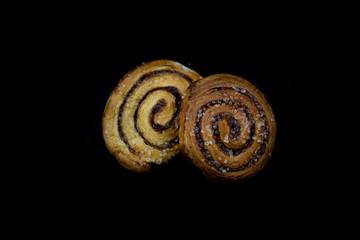 Fototapeta premium Tasty curly cinnamon cake. Sweet pastries on a dark kitchen table.