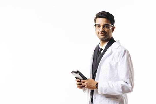Portrait of a man in business suit, lab coat and protective glasses, holding tablet,  isolated on white studio background
