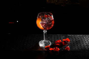 Top view of elegant glass filled with a fresh and tasty Aperol syringe summer cocktail on the black background