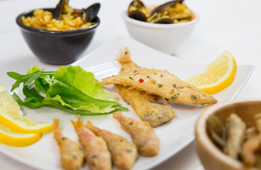 Fried fish and rice with mussels on dish with lemon and salad. Typical sicilian food