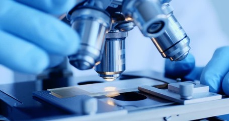Scientist hands with microscope close-up shot in the laboratory - Powered by Adobe