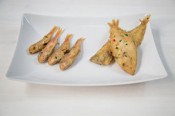 Fried fish on white dish. Typical sicilian food