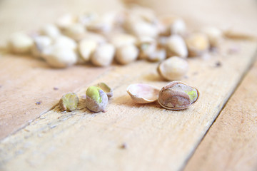 Pistachio nuts on a burlap fabric on a natural wooden table in a rustic kitchen. Empty copy space for Editor's text.