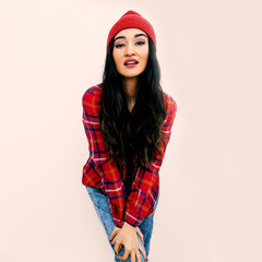 Stylish brunette Model. Urban Fashion Outfit. Checkered shirt, jeans and beanie cap. Red vibes