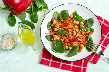 Vegetarian salad with chickpea, carrot, sweet pepper and spinach