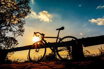 Fototapeta na wymiar cyclist with a bike silhouette on sunset sky background