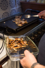 Senior man making grilled lamb chops at home. 