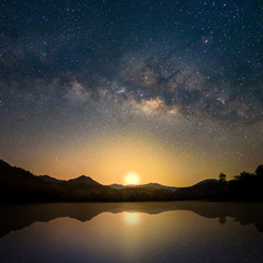 Fototapeta na wymiar Beautiful Milky Way Reflection on Lake in morning with first light of sunrise, Chiang mai , Thailand
