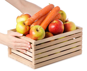 Wooden box of apples carrots female hand