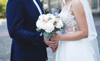 Happy bride and groom are holding bridal bouquet