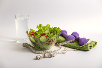 proper nutrition, fitness food, vegetable salad, diet program, dumbbells. concept of healthy food on a white background for advertising your text