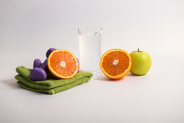 proper nutrition, fitness food, water, fruit, green apple, kiwi, orange. program of diet, dumbbells. concept of healthy food on a white background for advertising your text