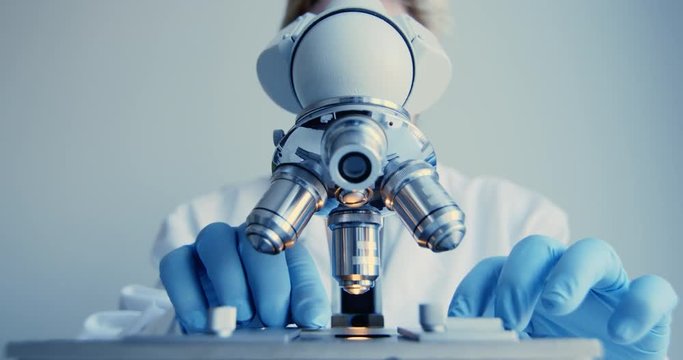 Scientist hands with microscope close-up shot in the laboratory