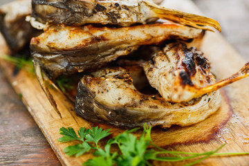 yammy grilled fish pieces with parsley on the board