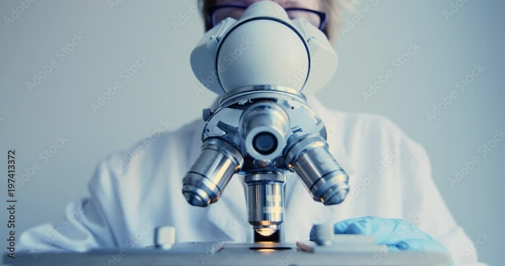 Wall mural scientist hands with microscope close-up shot in the laboratory