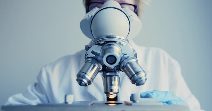 Scientist hands with microscope close-up shot in the laboratory