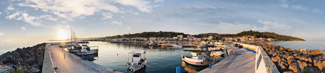 Fototapeta na wymiar Panorama of town Nea Skioni, Kassandra, Greece. Beautiful sunset at Nea Skioni, view from port.