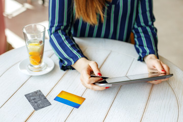 Girl who buys online with a tablet and a credit card. The concept of online shopping, lifestyle, business.