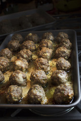 Baked meatballs on a sheet pan hot right out of the oven and cheese melted around