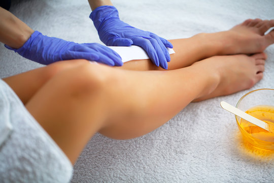 Waxing. Beautician Waxing Woman's Leg In Spa Salon