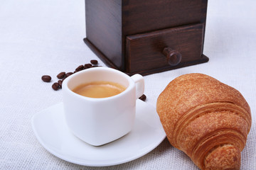 Classic espresso in white cup, croissant and coffee beans on white background. Top view.