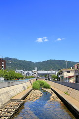 Obraz premium 初夏の河川敷で水遊びをする親子、神戸市灘区都賀川にて