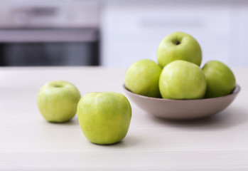 Plate with ripe green apples on table