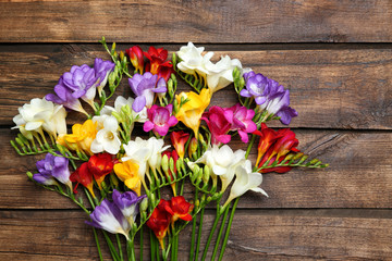Beautiful freesia flowers on wooden background