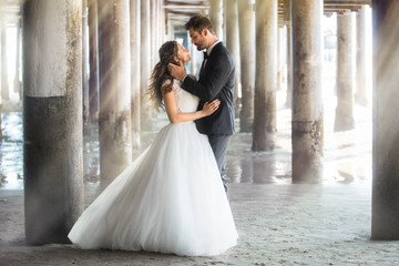 Dream like portrait of newlywed married couple in love holding each other outdoors