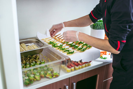 Chief at kitchen prepareing delicates, appetizers. Catring service. Closeup shoot of hands.