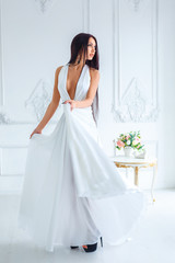 Fototapeta na wymiar beautiful slender brunette stands in a white dress