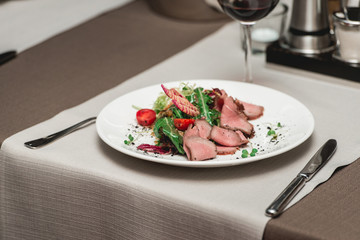 fresh salad with meat and tomatoes in a restaurant