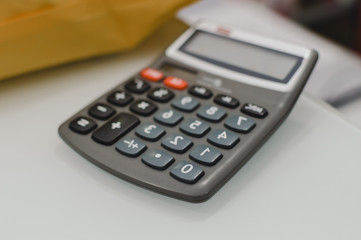 Closeup on calculator over light desk background. Top side view flat lay style of digital compute technology idea