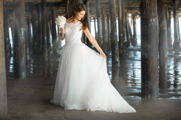 Fototapeta premium Dreamlike outdoor portrait of beautiful young bride in princess style gown dress